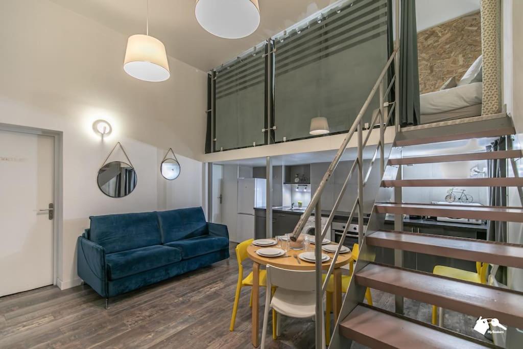 un salon avec une table et un canapé bleu dans l'établissement MBA Splendide Appart - Tracy 1 - Proche du Musée du Louvre, à Paris