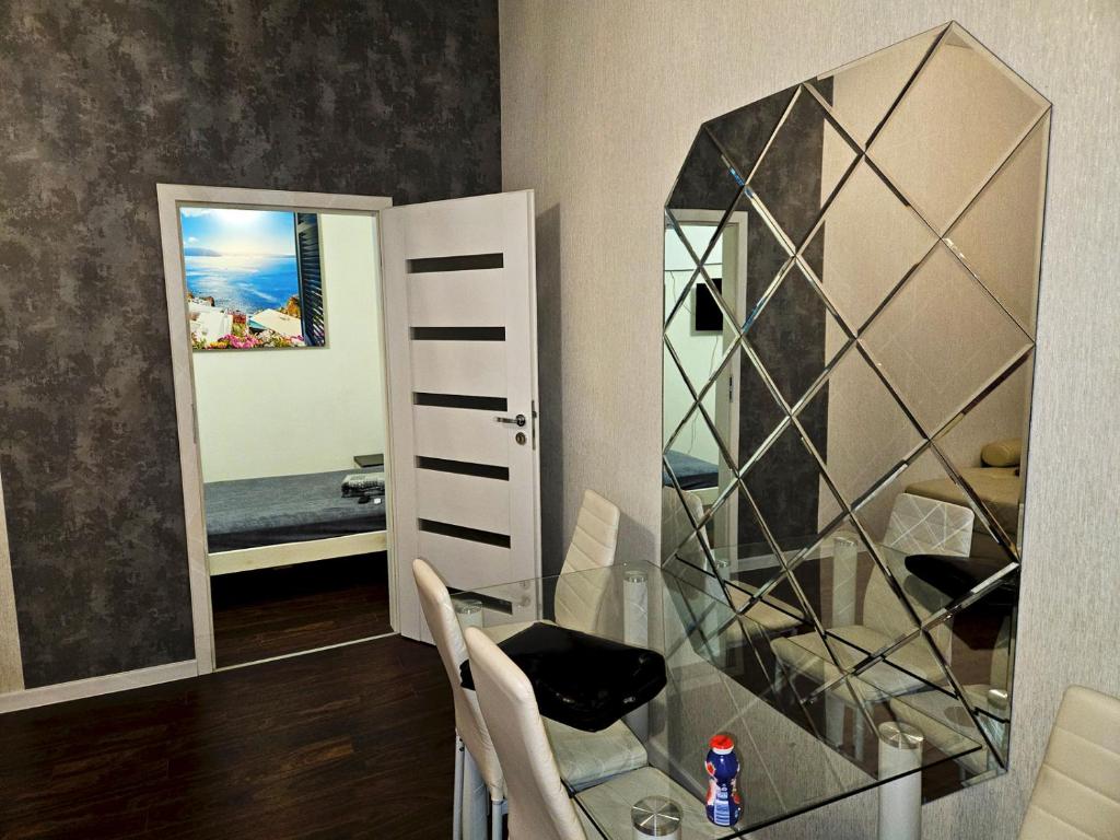 ein Esszimmer mit einem Glastisch und einem Spiegel in der Unterkunft Apartament Moniuszki Starówka Bytom 40m2 in Bytom