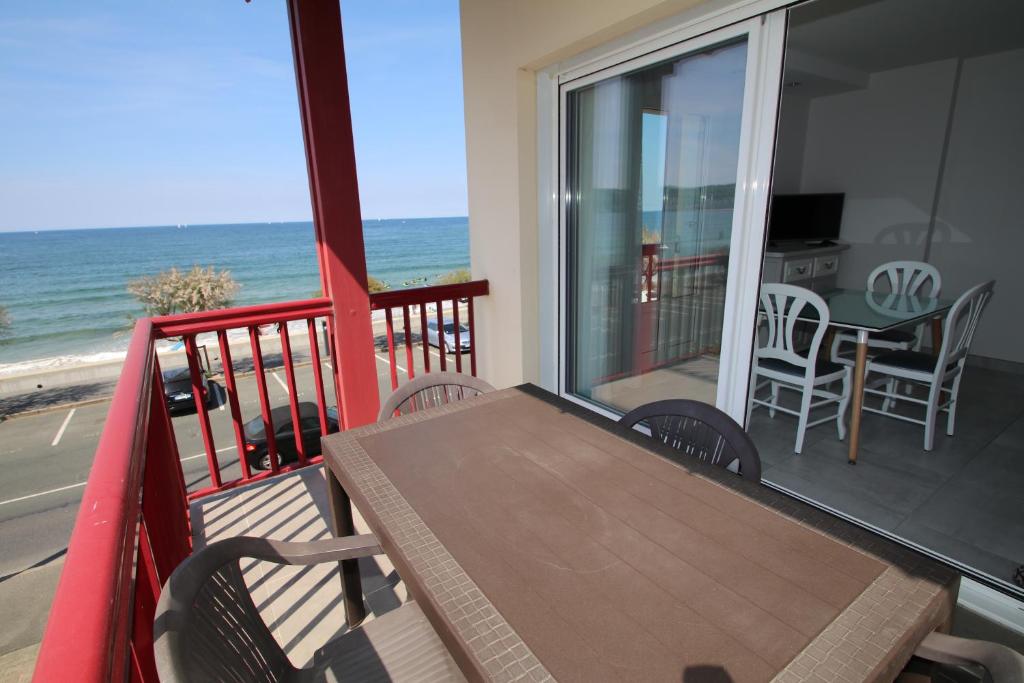 een balkon met een tafel en stoelen op het strand bij Résidence ITXASOA - Appartements, plage d'Hendaye in Hendaye