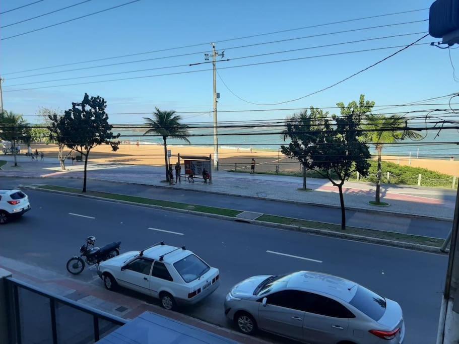 een straat met twee auto's geparkeerd aan de kant van een strand bij Loft Maria Helena I in Vila Velha