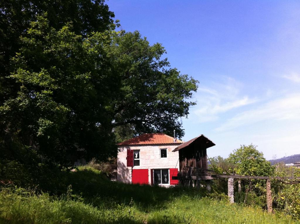 ein altes Haus auf einem Hügel mit einem Baum in der Unterkunft Eira das Carvalhas in Penafiel