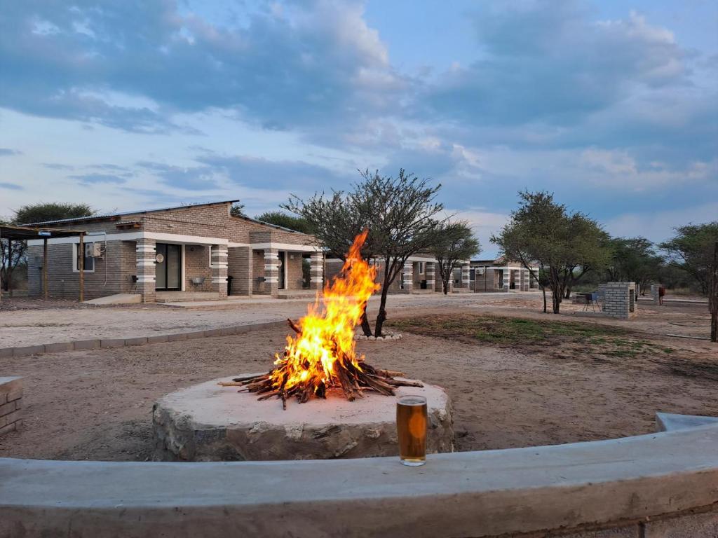 a fire pit with a glass of beer in it at Ghanzi Travel and Accommodation in Ghanzi