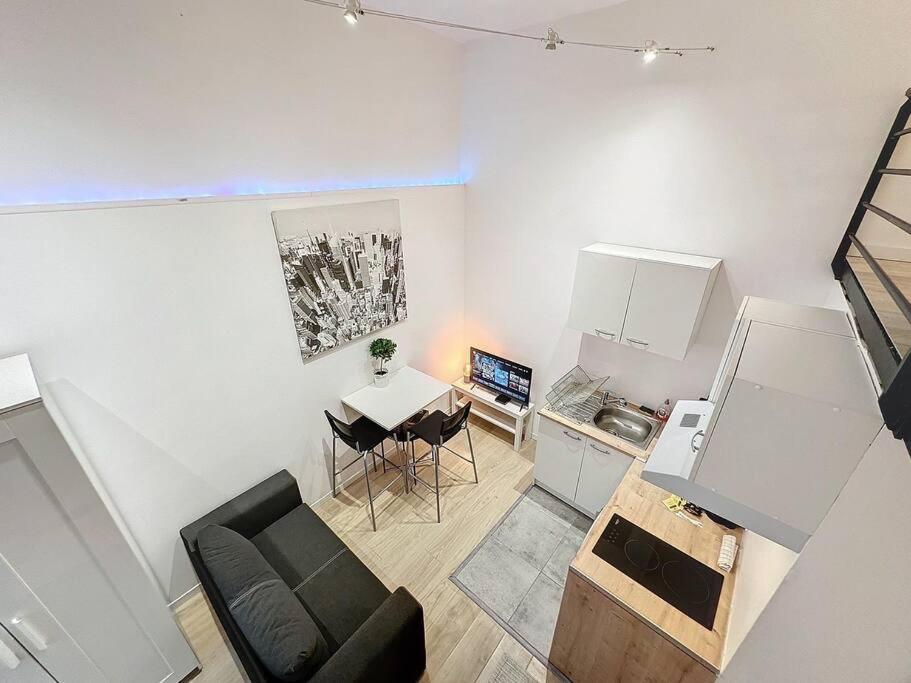 un salon avec un canapé et une table et une cuisine dans l'établissement Cosy appartement, Villeurbanne Frappaz, à Villeurbanne
