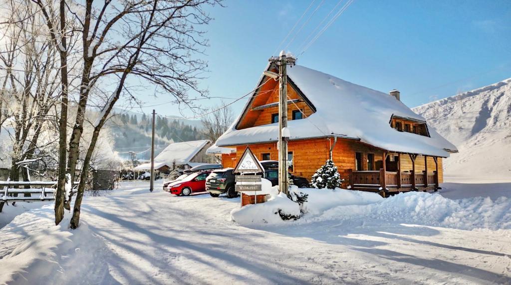 Cabaña de madera con nieve en el techo en Chata Škerda - Zuberec, en Zuberec