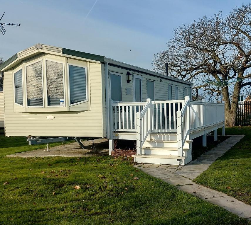 a blue and yellow house with a porch at 3-Bed homely modern caravan in Clacton-on-Sea in Clacton-on-Sea
