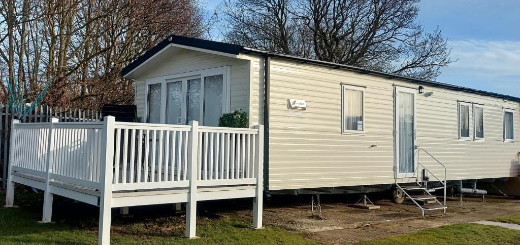 濱海克拉克頓的住宿－Impeccable 3-Bed Caravan in Clacton-on-Sea，白色的小房子,有白色的围栏