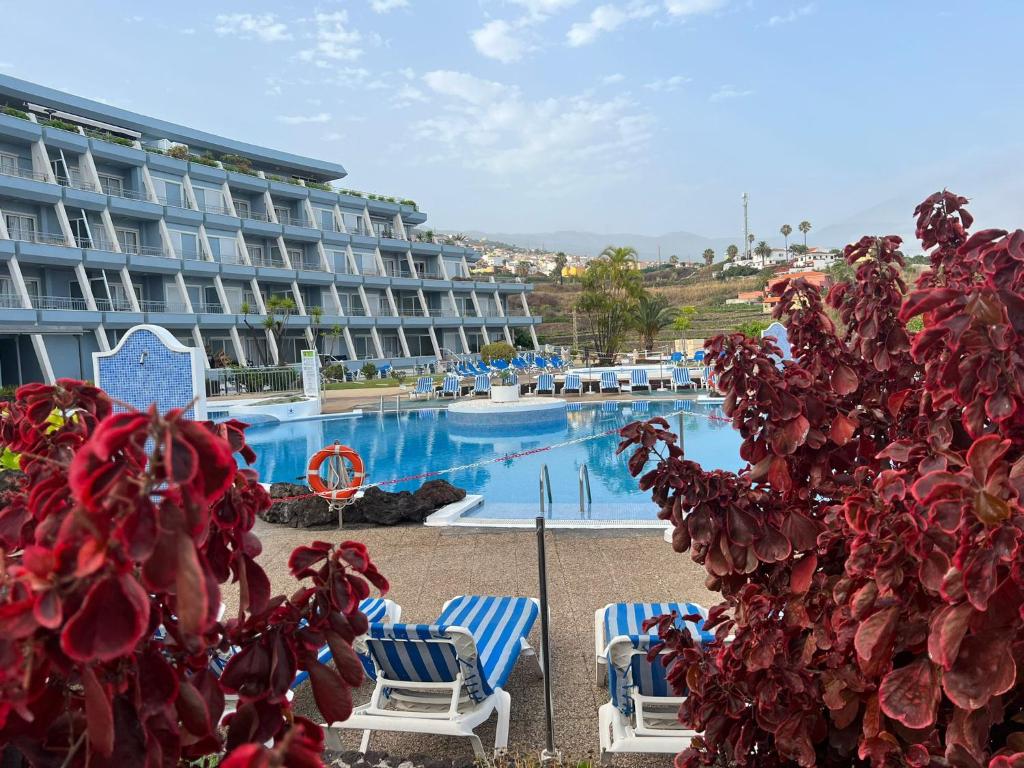 a hotel with a large swimming pool with two chairs at D-espacios elevados Quinta in Santa Úrsula