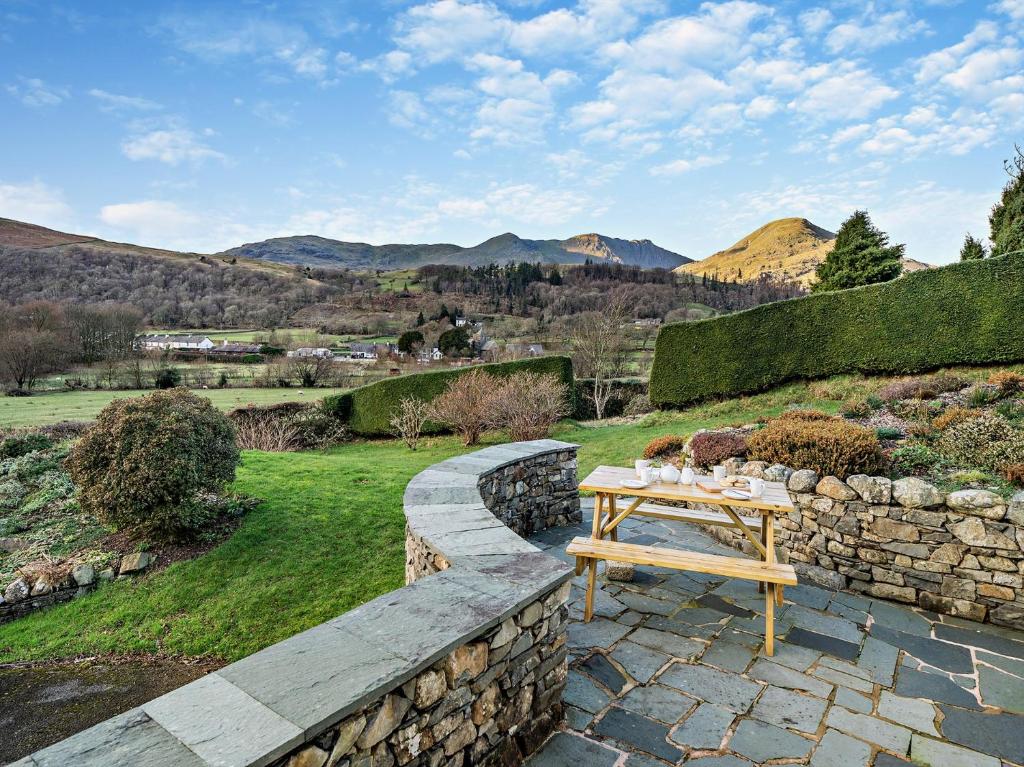 a wooden bench sitting on top of a stone wall at 3 Bed in Coniston 93329 in Torver