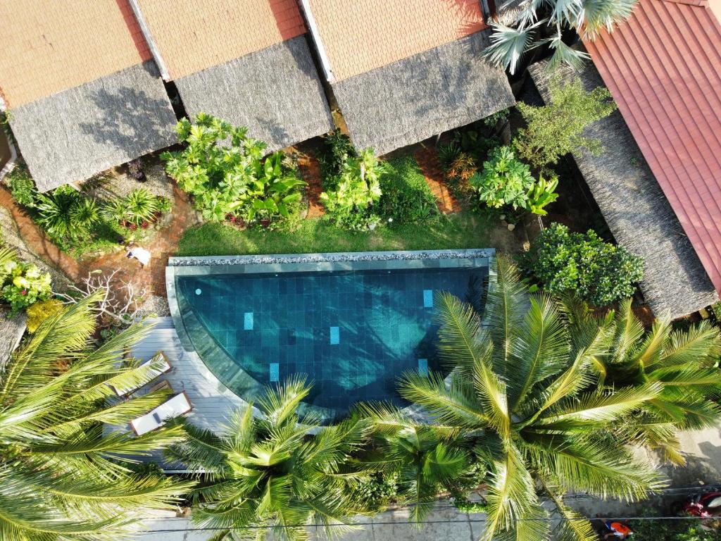 an overhead view of a swimming pool with palm trees at Pao Homes - An Bang Beach Stone Villa in An Bang