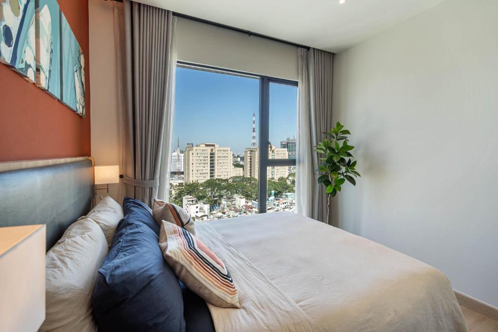 een slaapkamer met een bed en een groot raam bij Luxury Apartment with Saigon River View - Zenity in Ho Chi Minh-stad