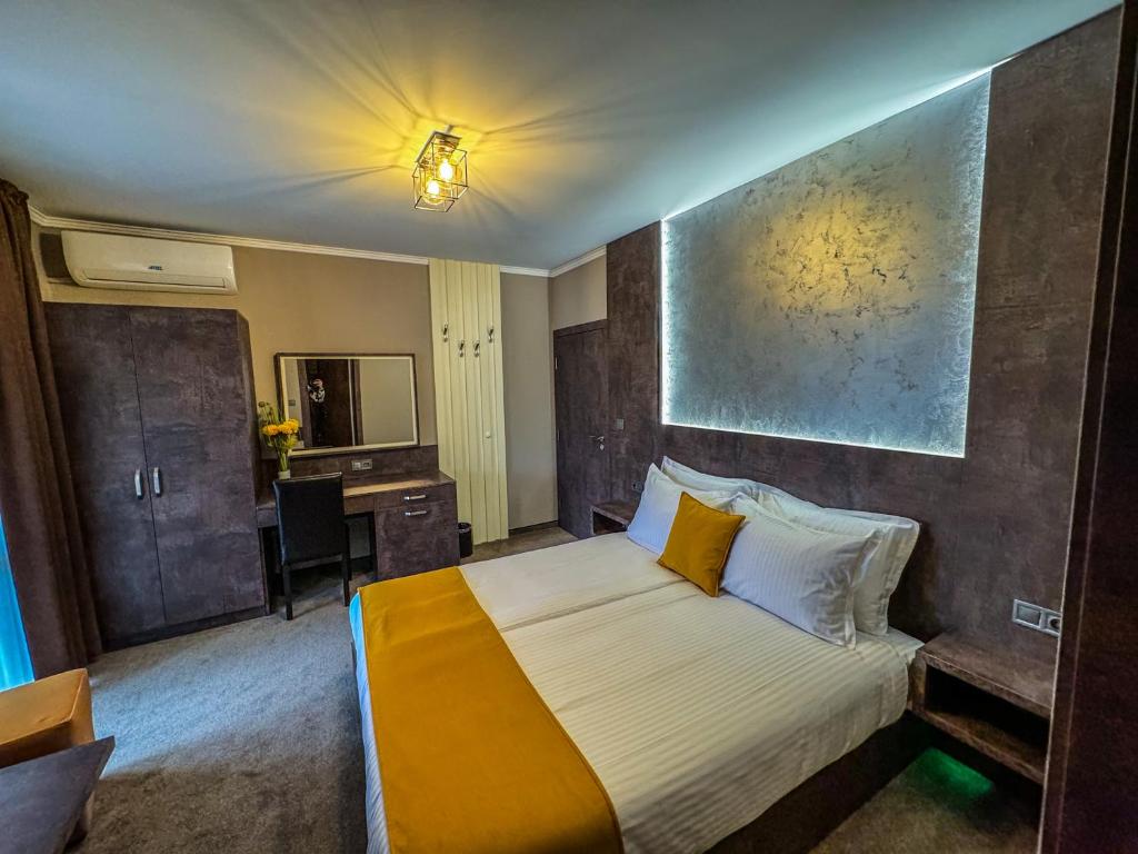 a hotel room with a bed and a desk in it at Стоичковата къща гр. Стрелча in Strelcha