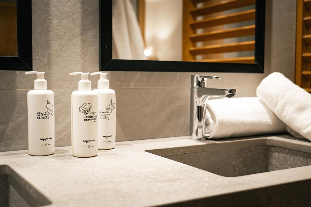 three bottles of soap sitting on a bathroom sink at htop Amatista #htopBliss in Lloret de Mar
