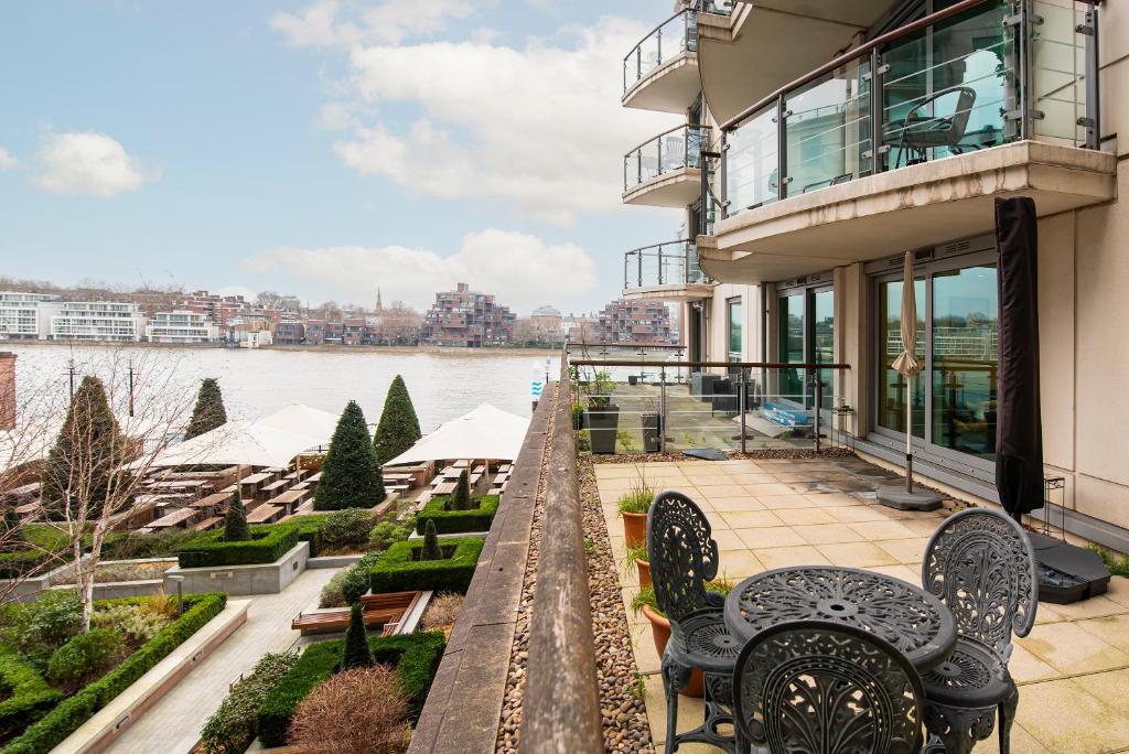 a balcony of a building with chairs and a river at Terraced riverview apartment in London