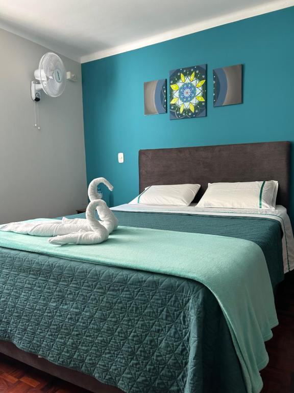 a bedroom with two beds with a swan on the bed at Dream Place Trujillo in Trujillo