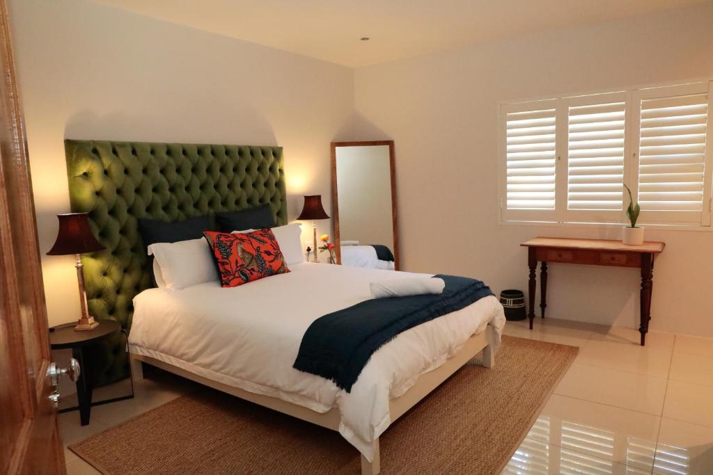 sypialnia z dużym łóżkiem z zielonym zagłówkiem w obiekcie Gorgeous 1-bedroom Sandton flat w mieście Johannesburg