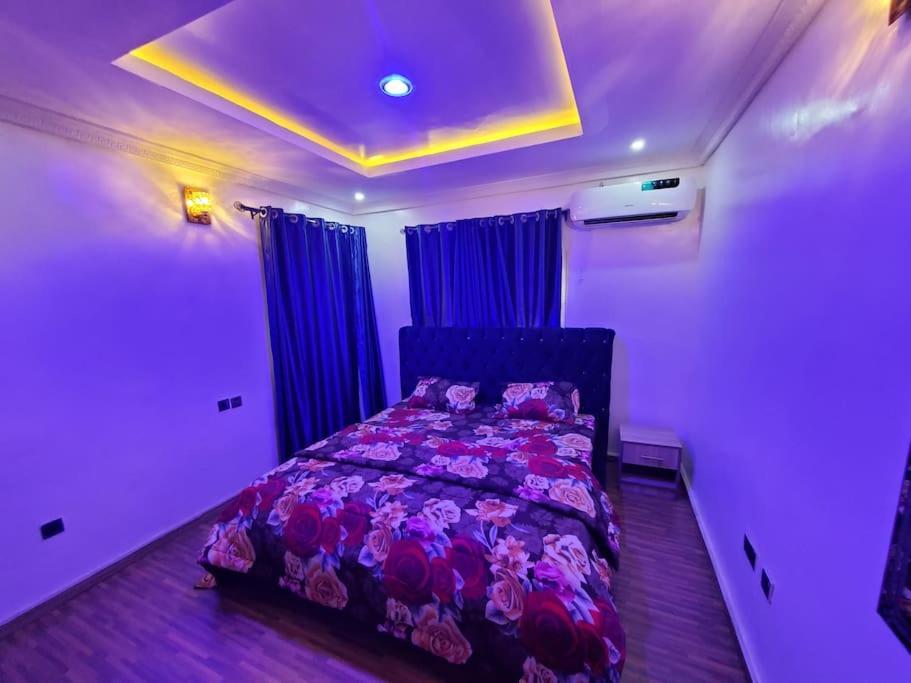 a bedroom with a bed in a room with purple lighting at Vim 2-BR-Apt With Fast Unlimited Internet & 24HRS Power in Lagos