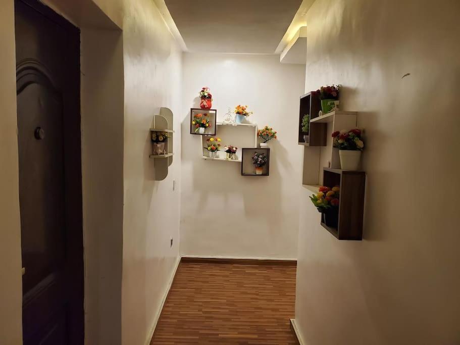 a hallway with flowers and pictures on a wall at Vim 2-BR-Apt With Fast Unlimited Internet & 24HRS Power in Lagos