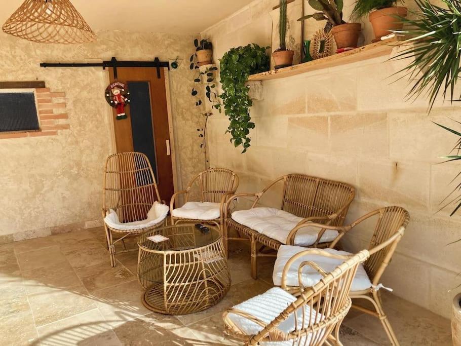 un grupo de sillas de mimbre y una mesa en un patio en Maison de campagne - La Belle Claudine, en Laruscade