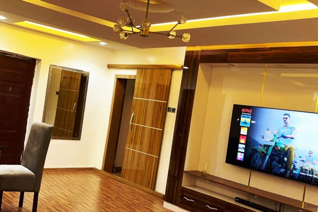 a living room with a flat screen tv on a wall at Vim 2-BR-Apt With Fast Unlimited Internet & 24HRS Power in Lagos