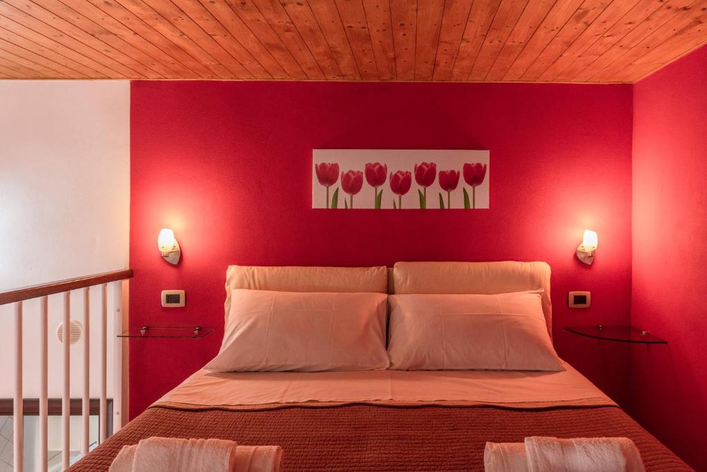 ein rotes Schlafzimmer mit einem Bett mit roten Wänden in der Unterkunft Il molo Apartment 1 in Porto Empedocle