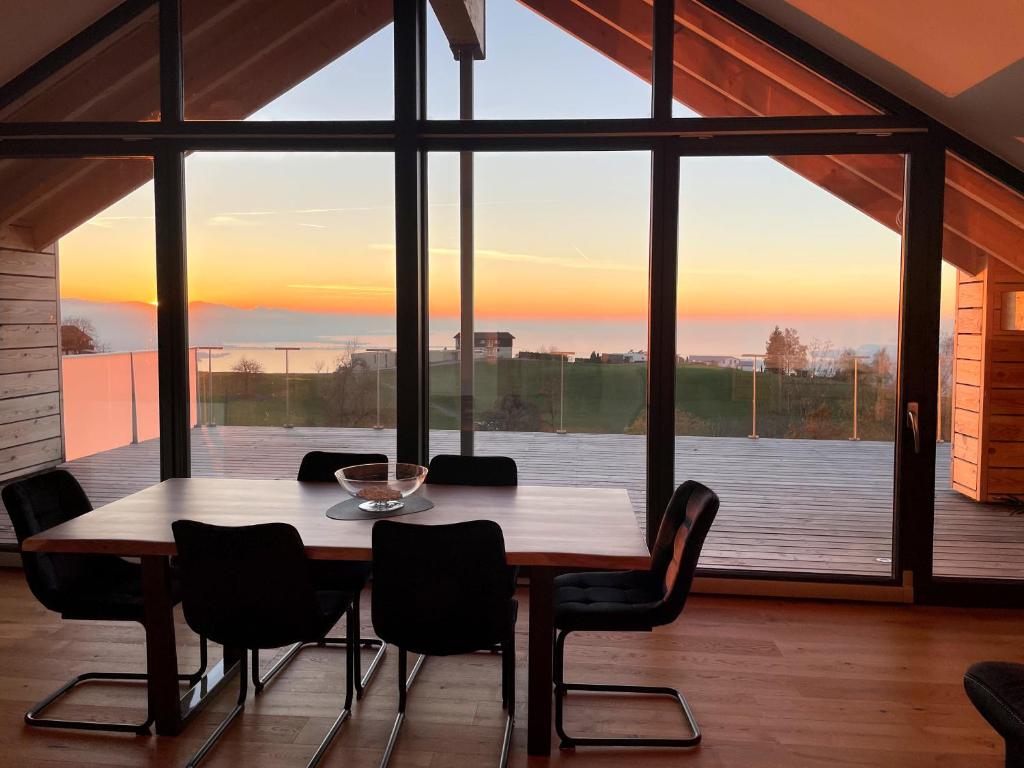 a wooden table and chairs in a room with a large window at Eichen-Chalet in Eichenberg