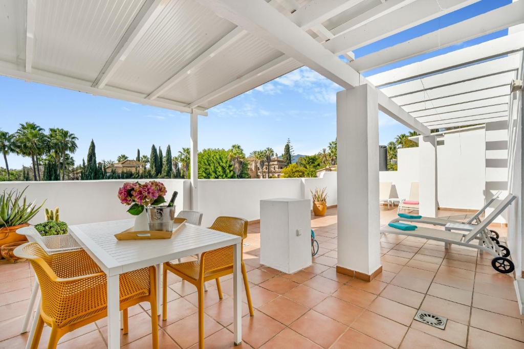 馬貝拉的住宿－Marbella Real - 2 Bedroom Apartment，白色的用餐室配有白色的桌椅