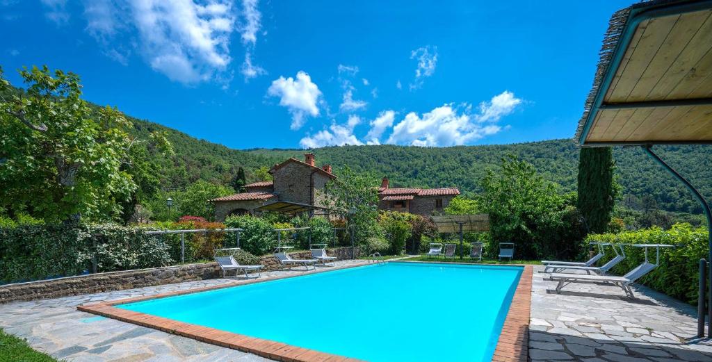 a swimming pool in front of a house at Colle Degli Ulivi - pool, nature, relax holiday home Cortona, Italia in Cortona