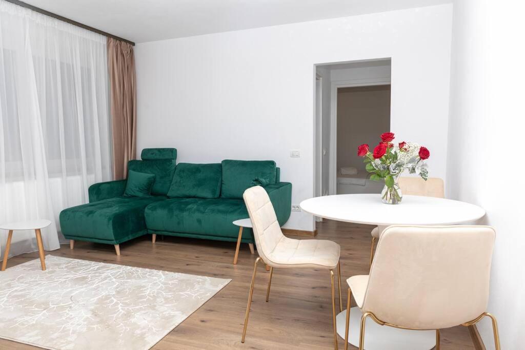 a living room with a green couch and a table at Enescu 3 City Center Flat in Timişoara