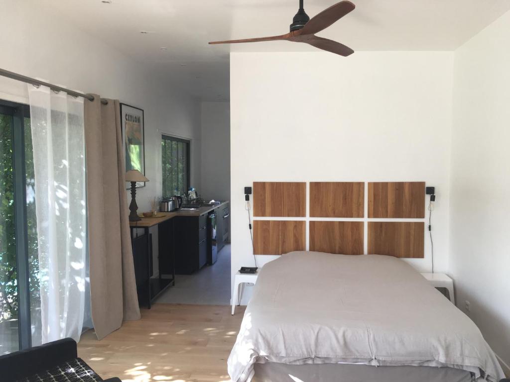 a bedroom with a bed and a ceiling fan at La Cabane in Bouliac