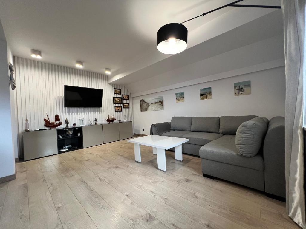 a living room with a couch and a table at Apartament Portowy in Hel