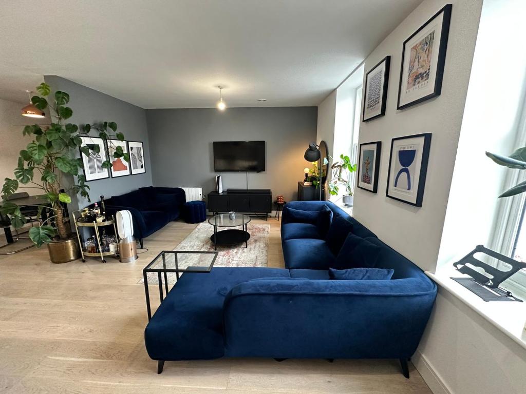a living room with a blue couch and a tv at West London Hideaway Suite in Ealing
