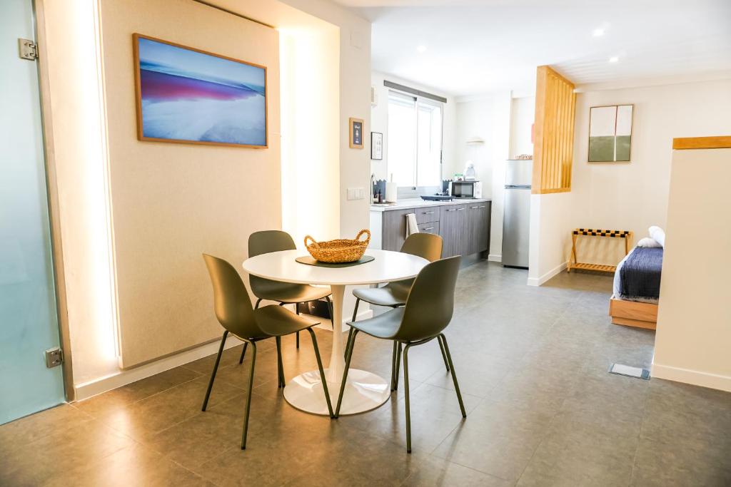 a dining room and kitchen with a table and chairs at Estudio Suite 408 in Alicante