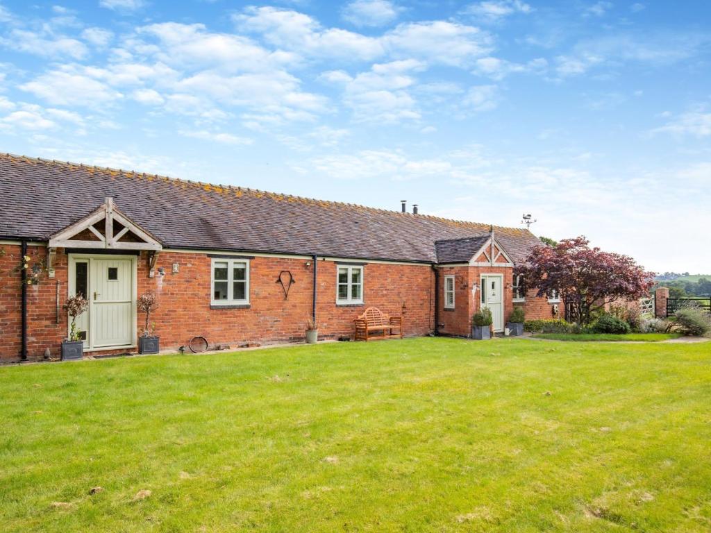 ein Backsteinhaus mit einem Rasenhof davor in der Unterkunft 4 Bed in Bishops Offley 93215 in Eccleshall