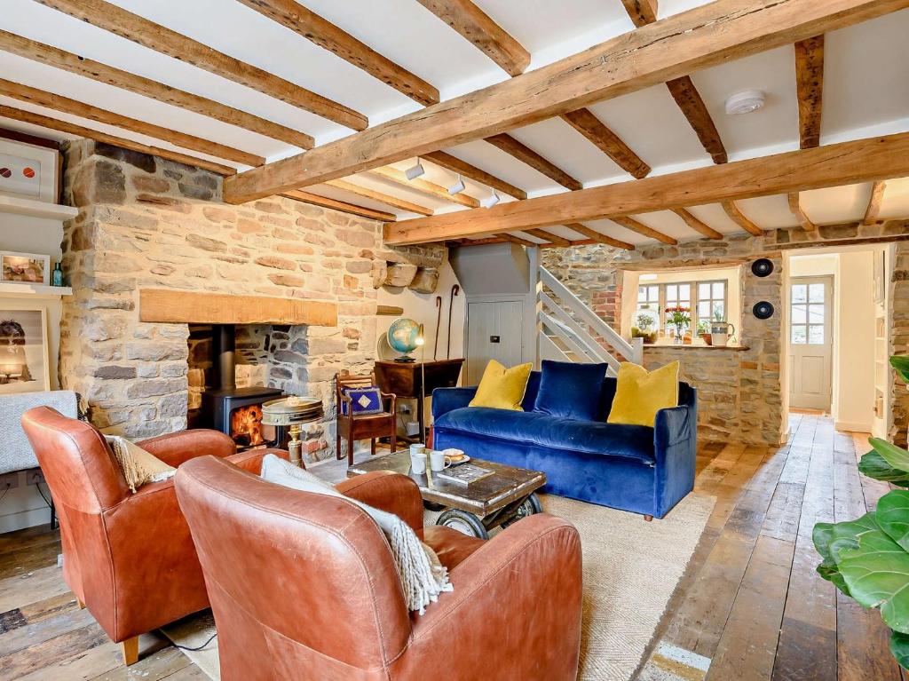 a living room with leather furniture and a stone wall at 2 Bed in Hay-on-Wye 93221 in Hay-on-Wye