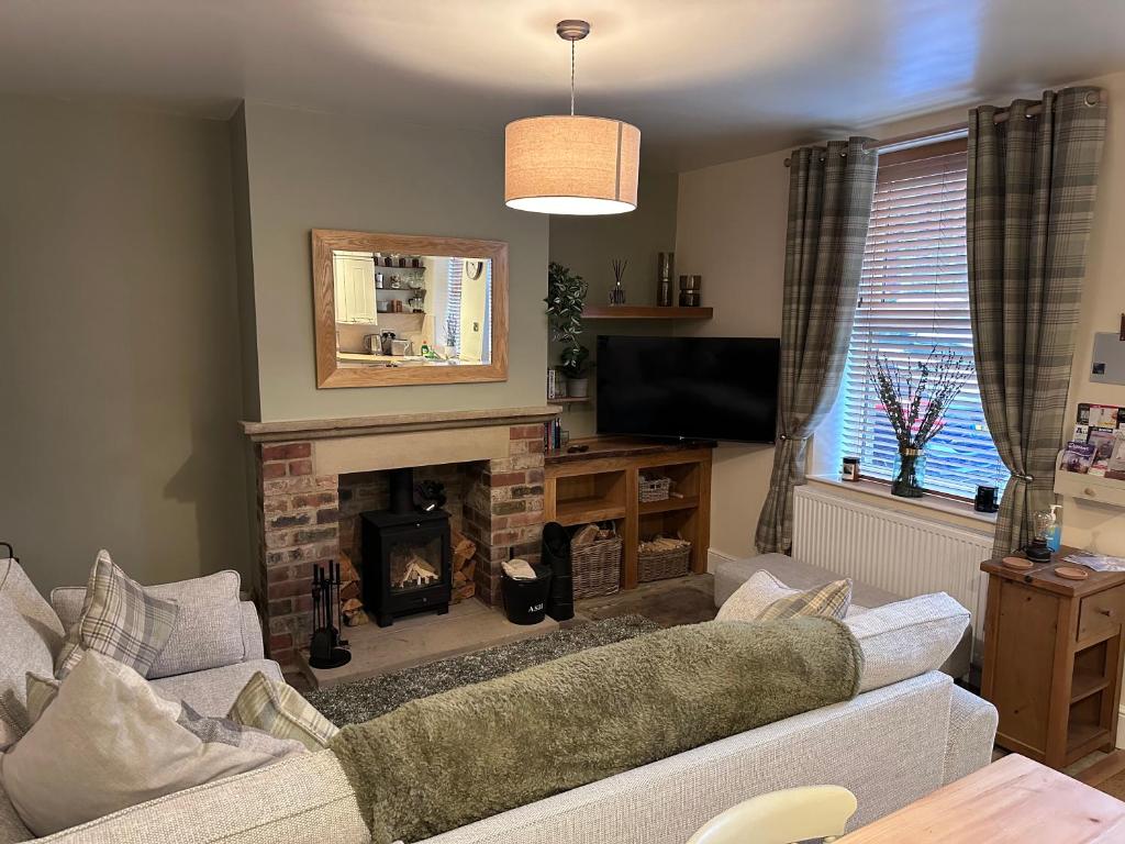 a living room with a couch and a fireplace at Prince Street Cottage - Haworth - Sleeps 4 in Haworth