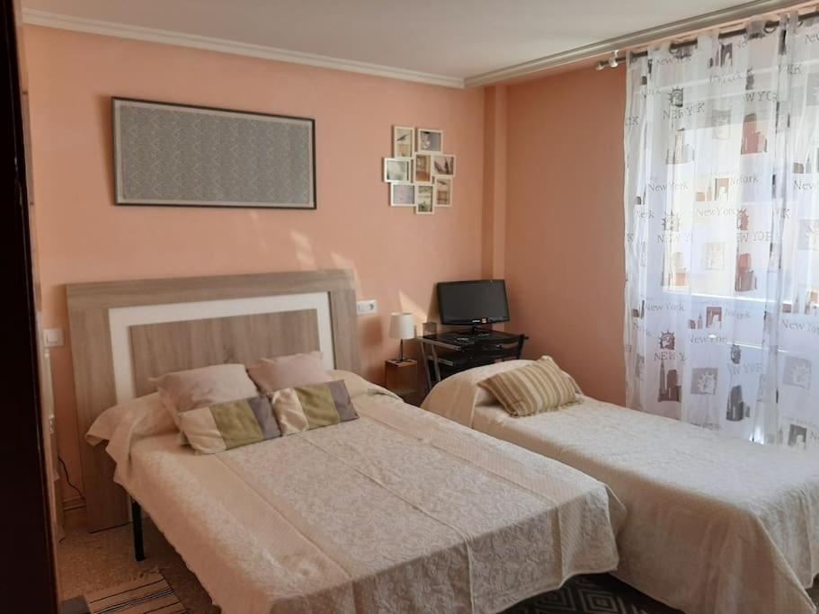 um quarto com duas camas e uma televisão em La Casa Céntrica Gijón em Gijón