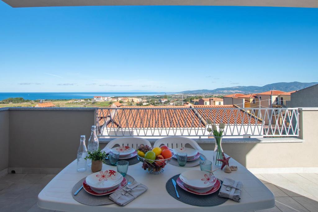 a table on a balcony with a view of the ocean at Pietra di Luna in Valledoria
