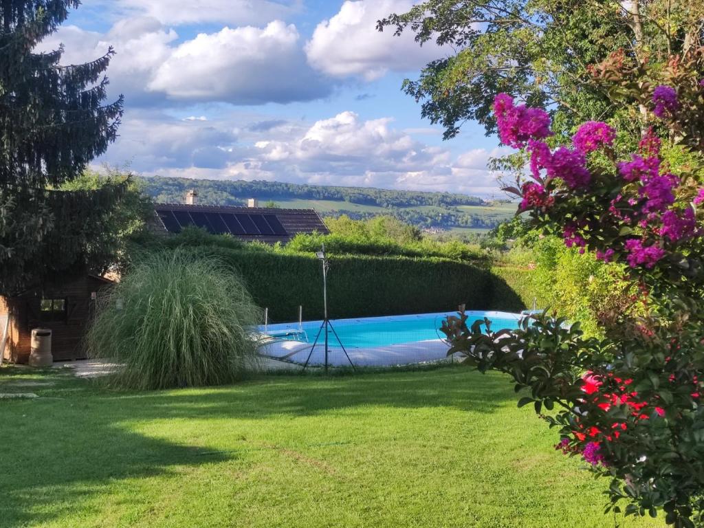 a garden with a swimming pool and flowers at Camping Nature et insolite proche Disneyland in Saâcy-sur-Marne