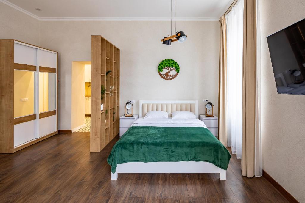 um quarto com uma cama com um cobertor verde em Leontovycha 1905 em Lviv