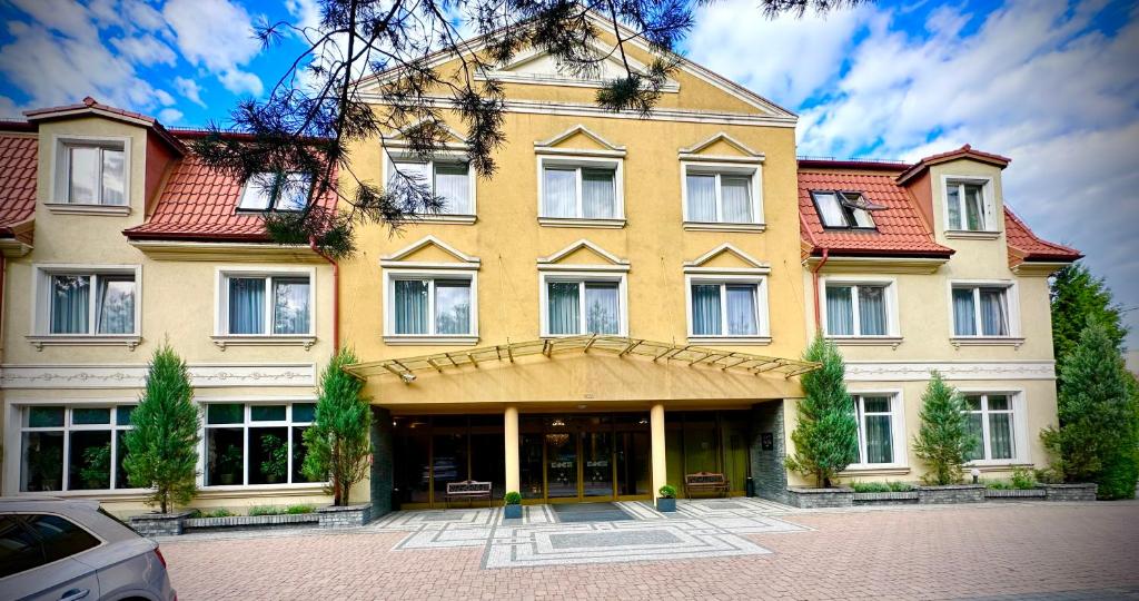 un gran edificio amarillo con techo rojo en Hotel Koch, en Kętrzyn