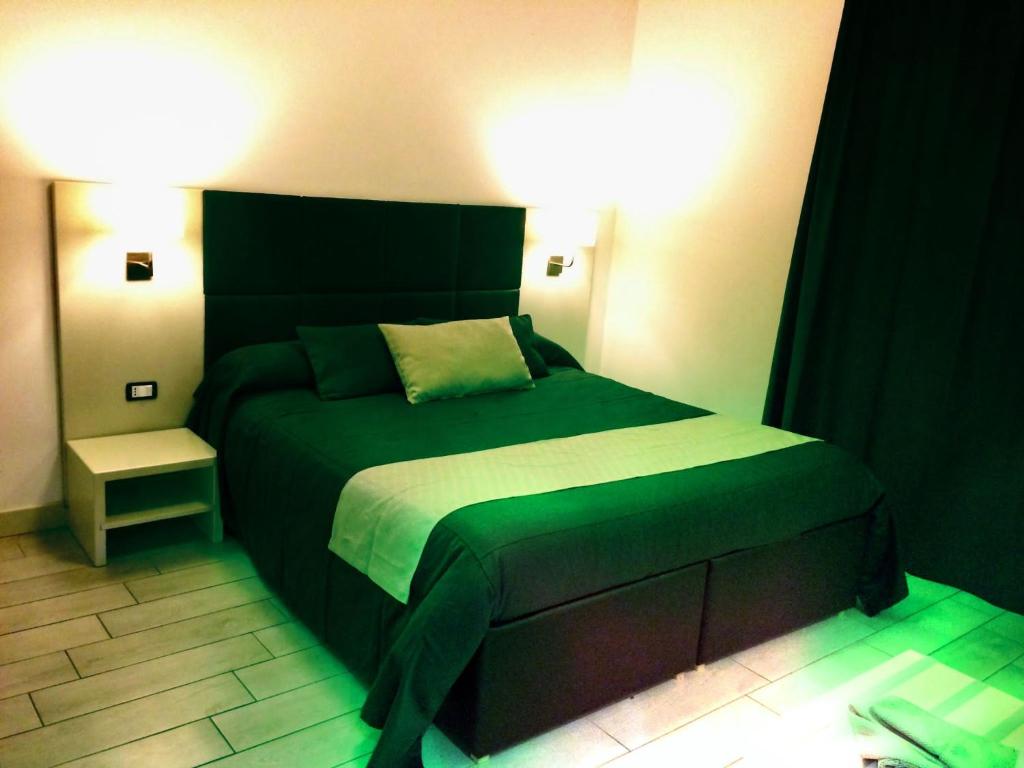 ein Schlafzimmer mit einem grünen Bett in einem Zimmer in der Unterkunft Ape in Marina di Schiavonea