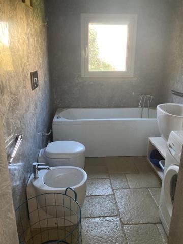 a bathroom with a toilet and a tub and a sink at Dimora Cavalieri charming house salento puglia in Andrano
