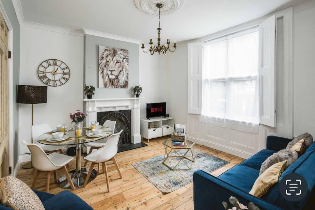 a living room with a blue couch and a table at Spacious 4 bed house in Croydon with parking for x2 cars! - Photo ID Required in South Norwood