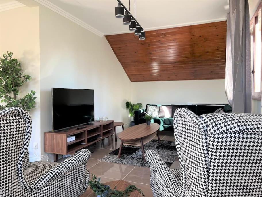 uma sala de estar com duas cadeiras e uma televisão em Park Résidence Divonne-les-Bains em Divonne-les-Bains