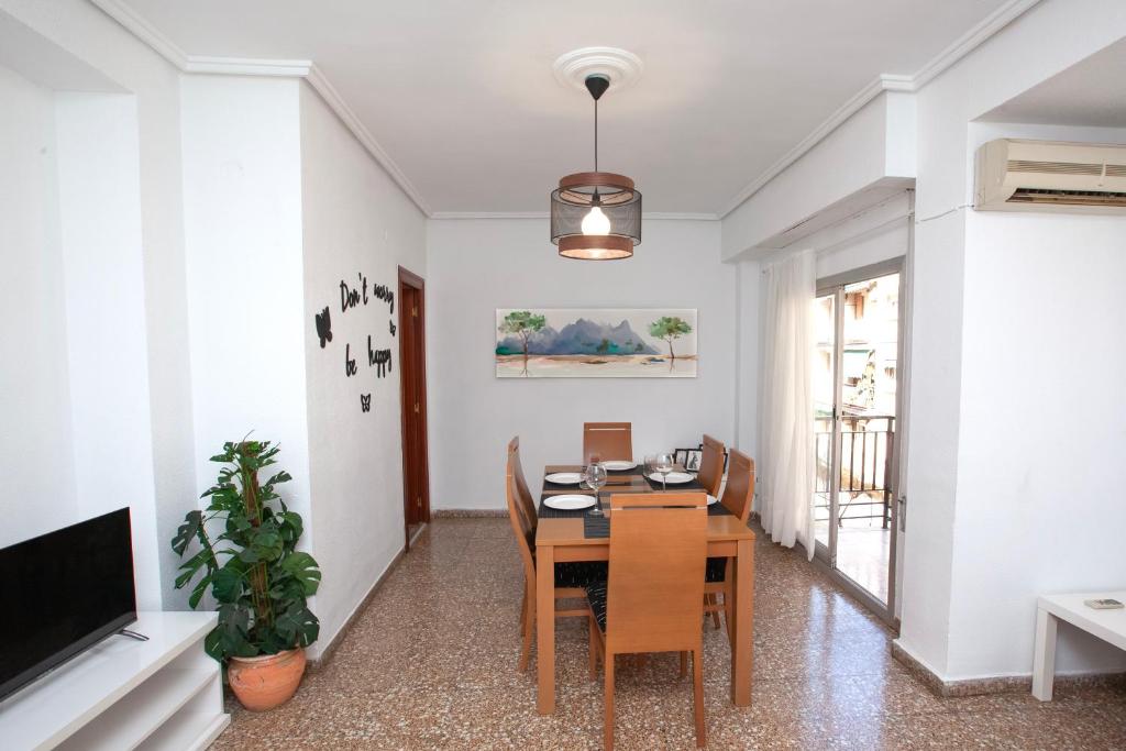 comedor con mesa y sillas en Acogedor apartamento valencia 3 dormitorios en Aldaia