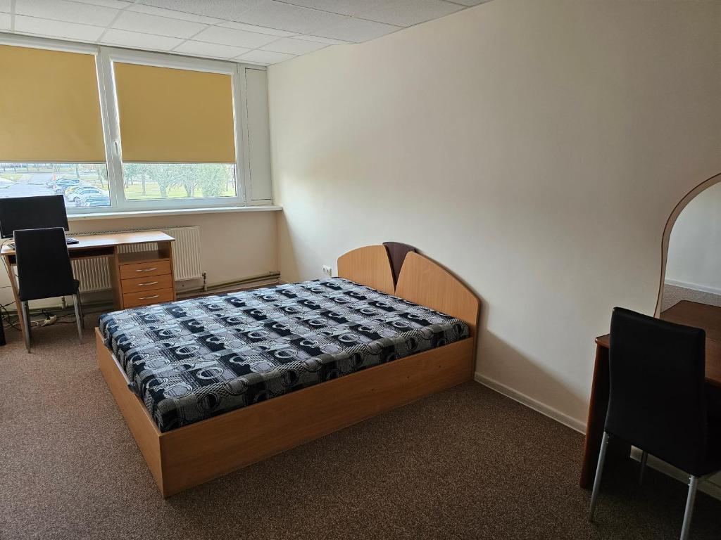 ein Schlafzimmer mit einem Bett in der Ecke eines Zimmers in der Unterkunft Kėdainių profesinio rengimo centras in Kėdainiai
