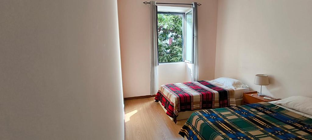 a room with two beds and a window at Residencial Monaco in Funchal