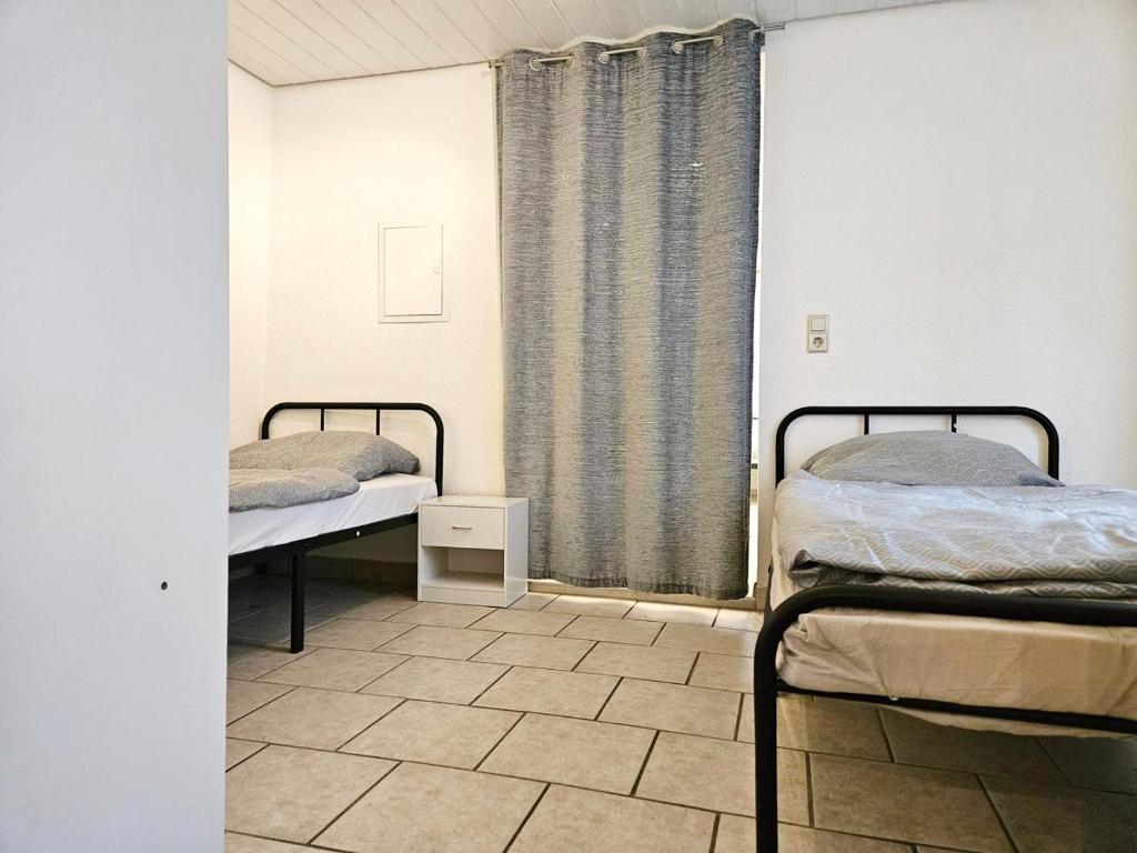 Duas camas num quarto com uma janela em Apartment in Vaihingen an der Enz - Horrheim em Vaihingen an der Enz