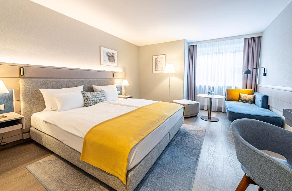 a hotel room with a large bed and a chair at Hotel Europa in Munich