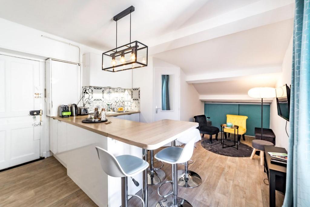 a kitchen with a table and chairs in a room at My little pleasure from the 8th AIL in Lyon